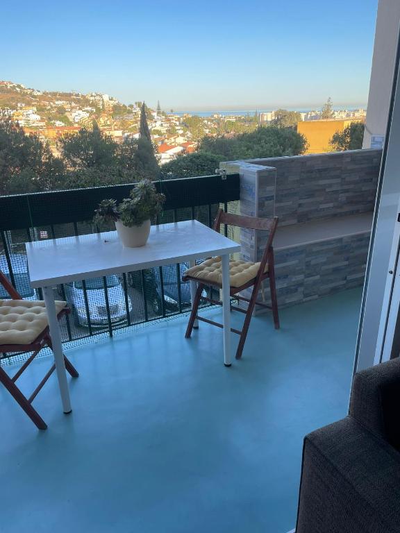 林孔-德拉维多利亚Habitación privada en Rincón的阳台上配有一张白色的桌子和两把椅子