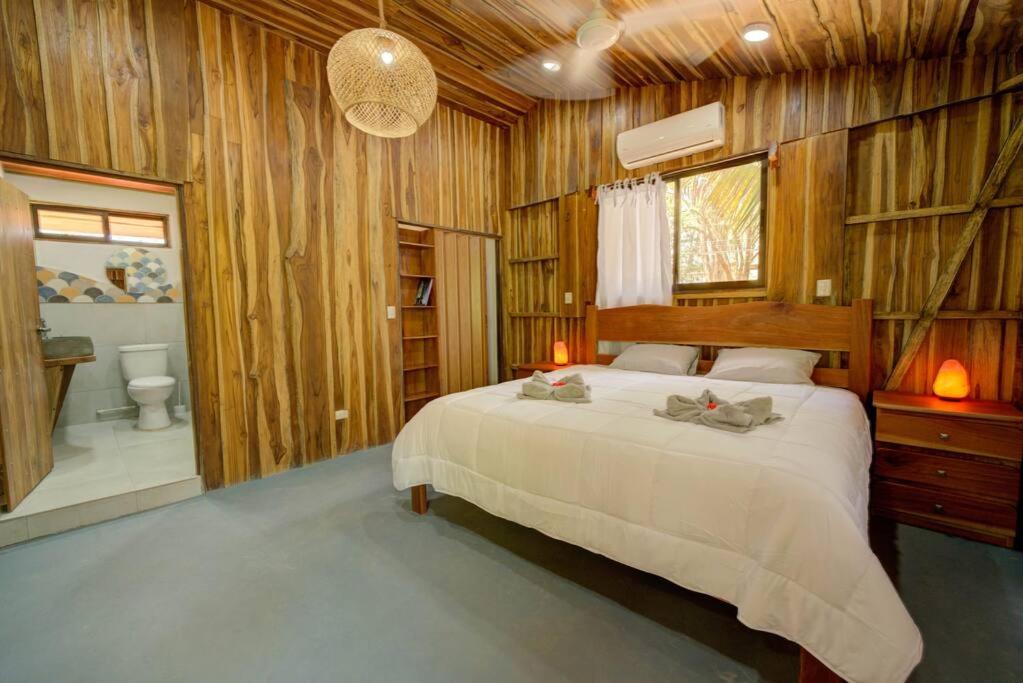 萨玛拉Sámara Tarantela Houses, Casa Bambú的一间卧室配有一张床,浴室设有卫生间