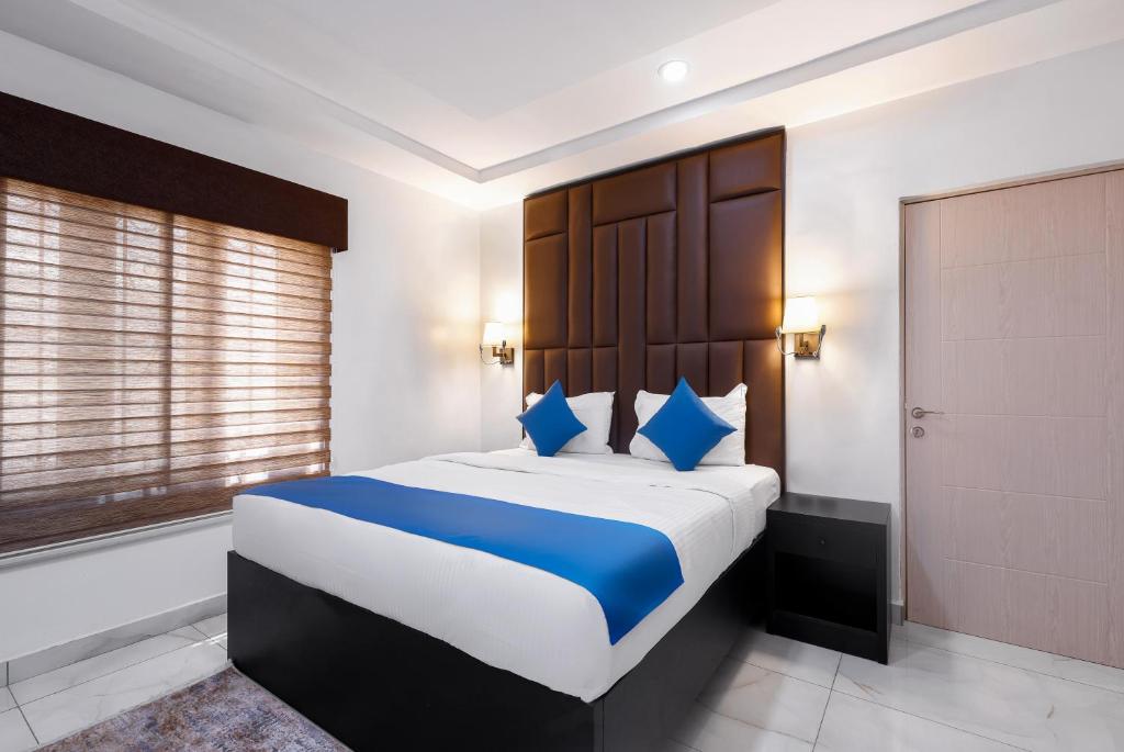 阿布贾BKT Cribs - Apartments & Suites的一间卧室配有一张带蓝色枕头的大床