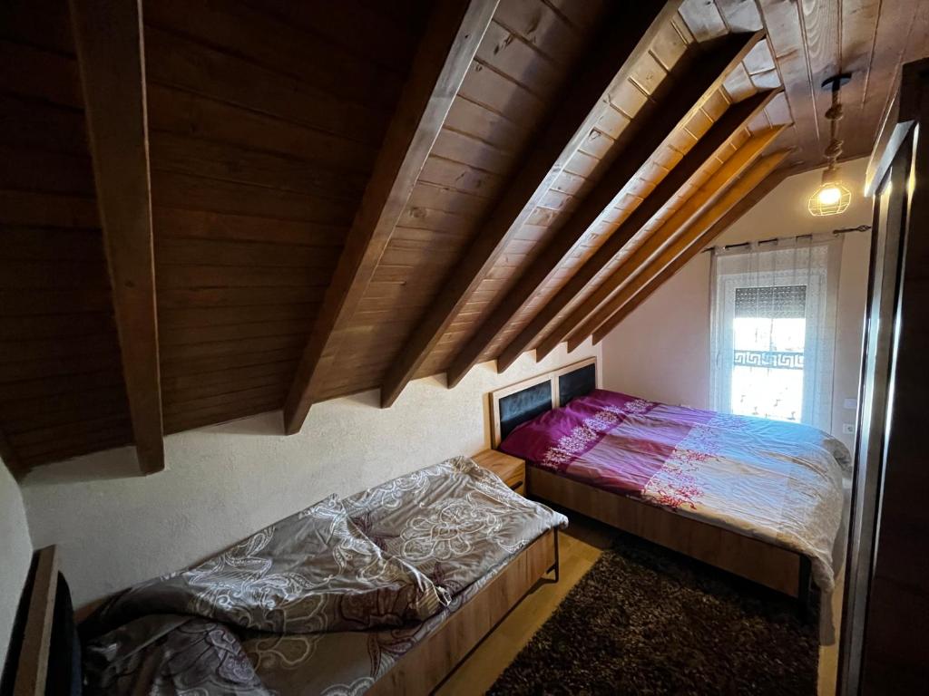 乌罗舍瓦茨Villa Peisazhi的阁楼卧室设有两张床和窗户。