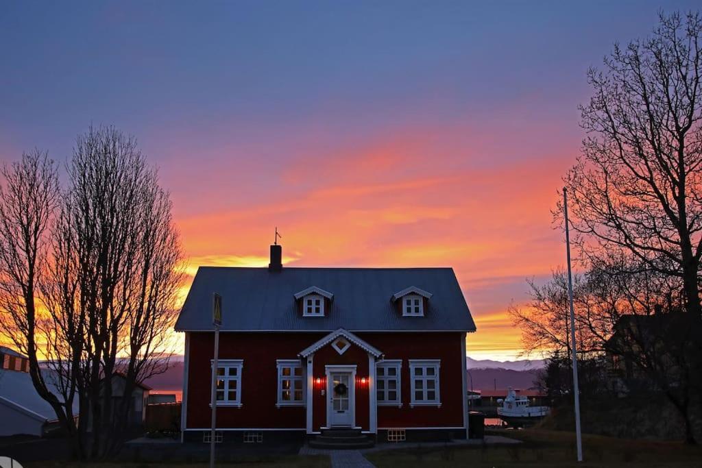 胡萨维克The Foreman house - an authentic town center Villa的红色房子,背景是日落