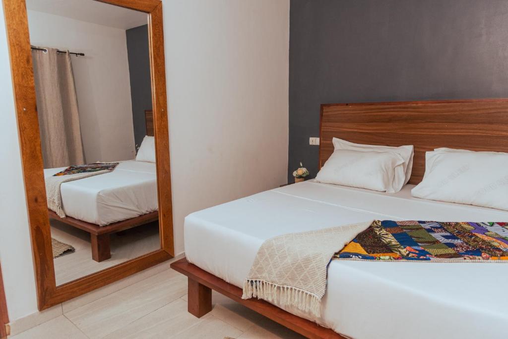 洛美Ahomé Guest house & Lounge的一间卧室配有两张床和镜子