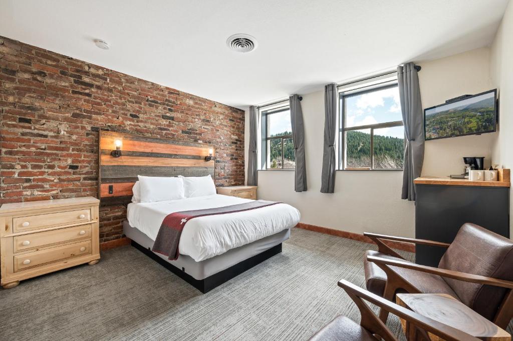 莱文沃思Hotel Leavenworth的一间卧室设有一张床和砖墙