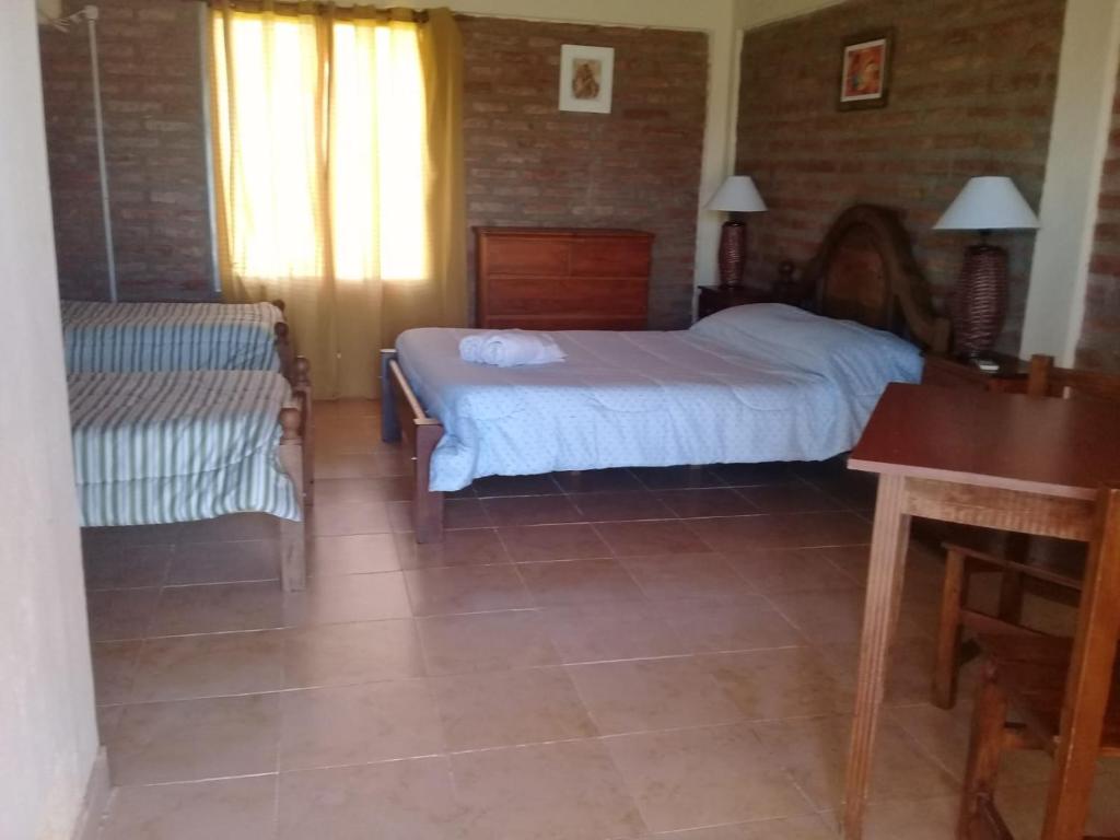 乌尼翁镇HOTEL FINCA AMANCAY的一间卧室配有一张床、一张长凳和一张桌子