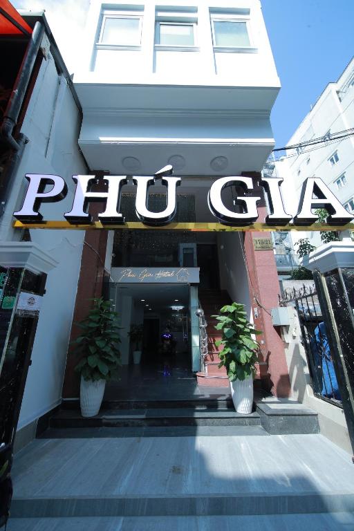 胡志明市PHÚ GIA BÙI VIỆN HOTEl的建筑前有两株盆栽植物的商店