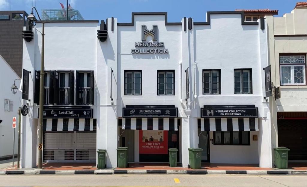 新加坡Heritage Collection on Chinatown - A Digital Hotel的白色的建筑,前面有标志