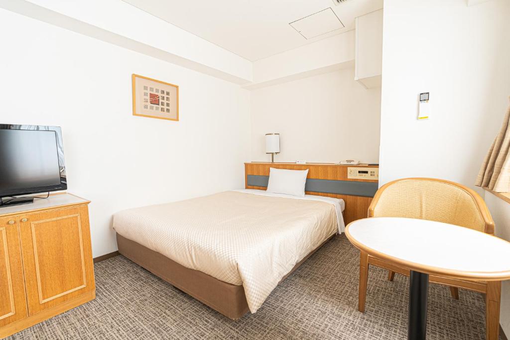 东京Forest Hongo by unito的客房设有1张床、1台电视和1张桌子。