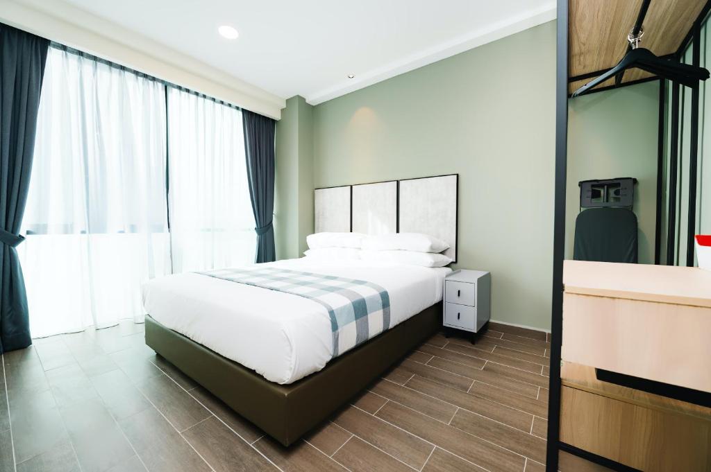 吉隆坡Chill Suites Kuala Lumpur的一间卧室设有一张床和一个大窗户