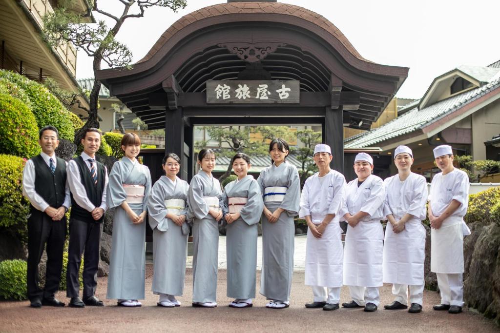 热海古屋旅馆的一群站在建筑物前的人