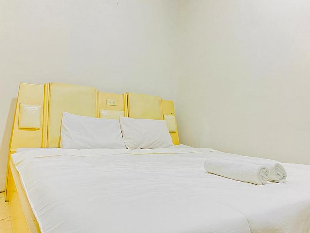 泗水Monalisa Homestay Mitra RedDoorz的一张白色大床,配有白色床单和枕头