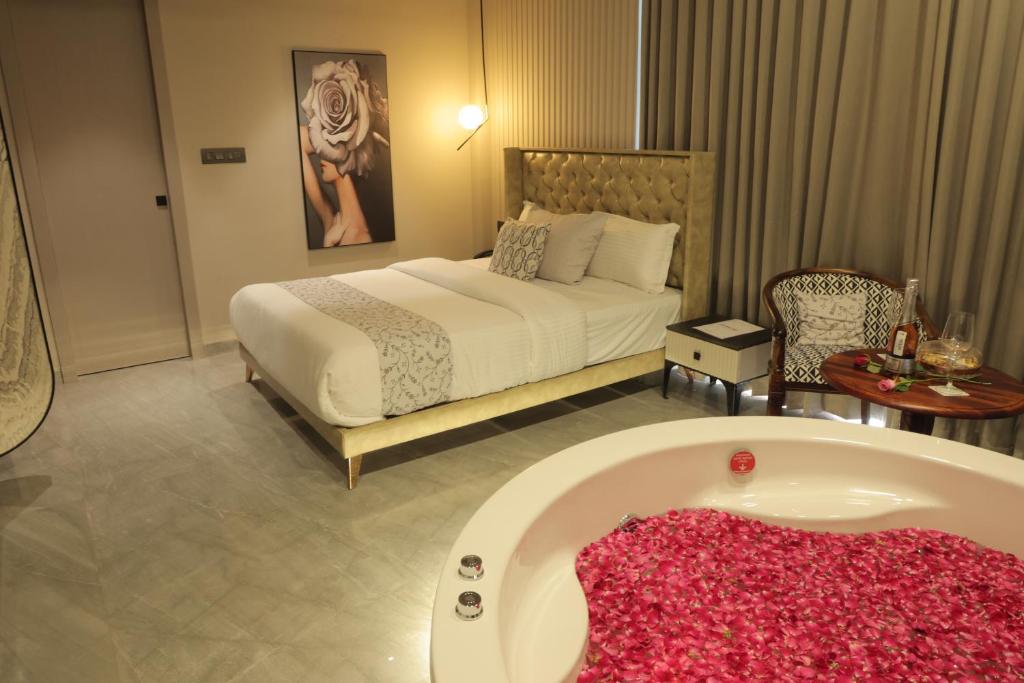 艾哈迈达巴德Apricot Motera的一间卧室配有一张床和浴缸