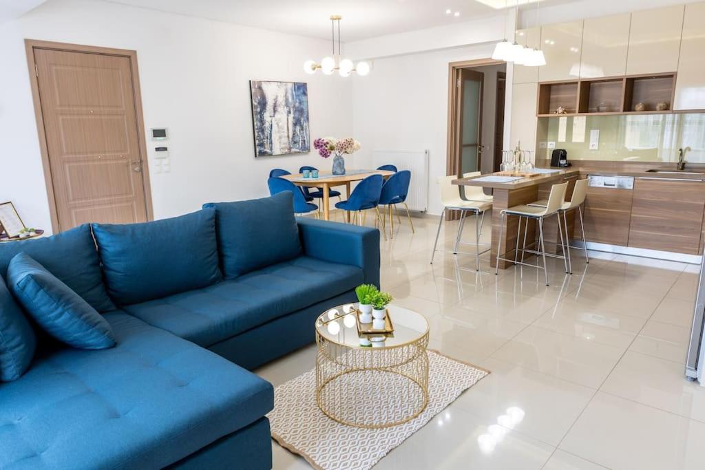 阿卡尼斯The Archanes Sapphire的一间带蓝色沙发的客厅和一间厨房