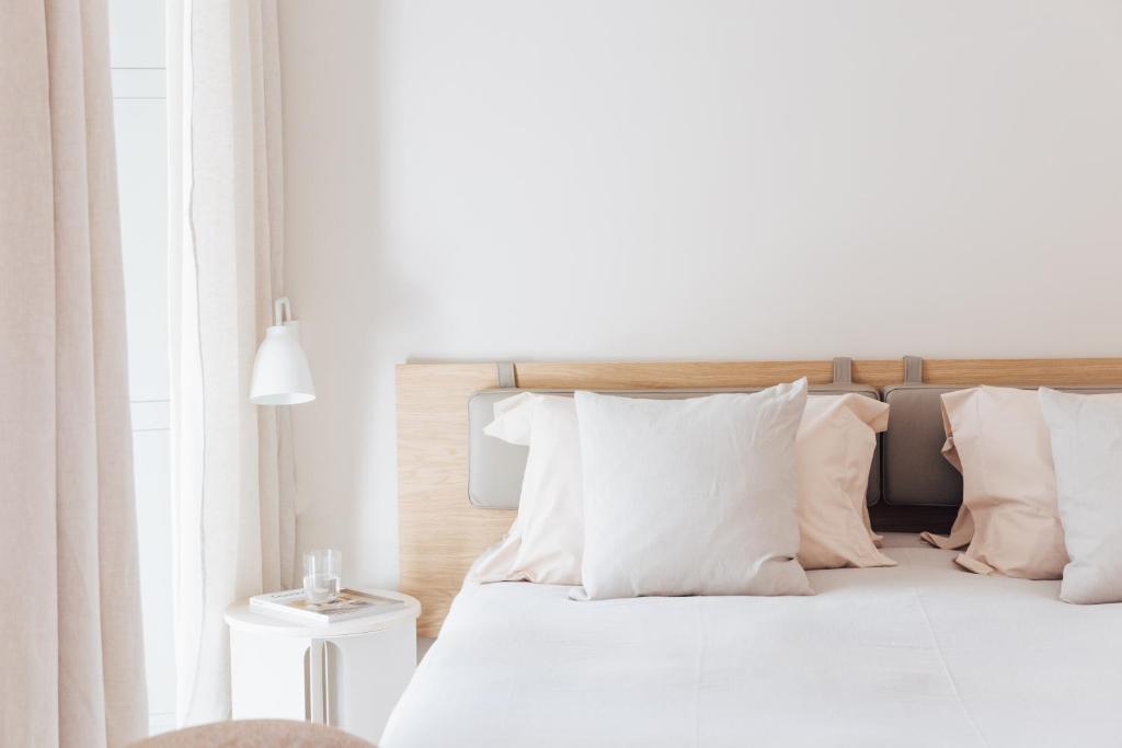 塞维利亚Plácido y Grata的白色卧室配有带白色枕头的床