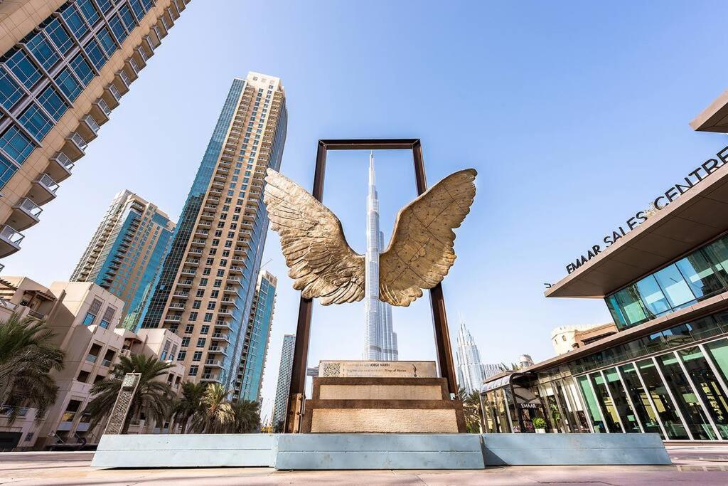 迪拜Lux Burj views -Boulevard -Prime Location Downtown DUBAI的天使的雕像,以城市为背景
