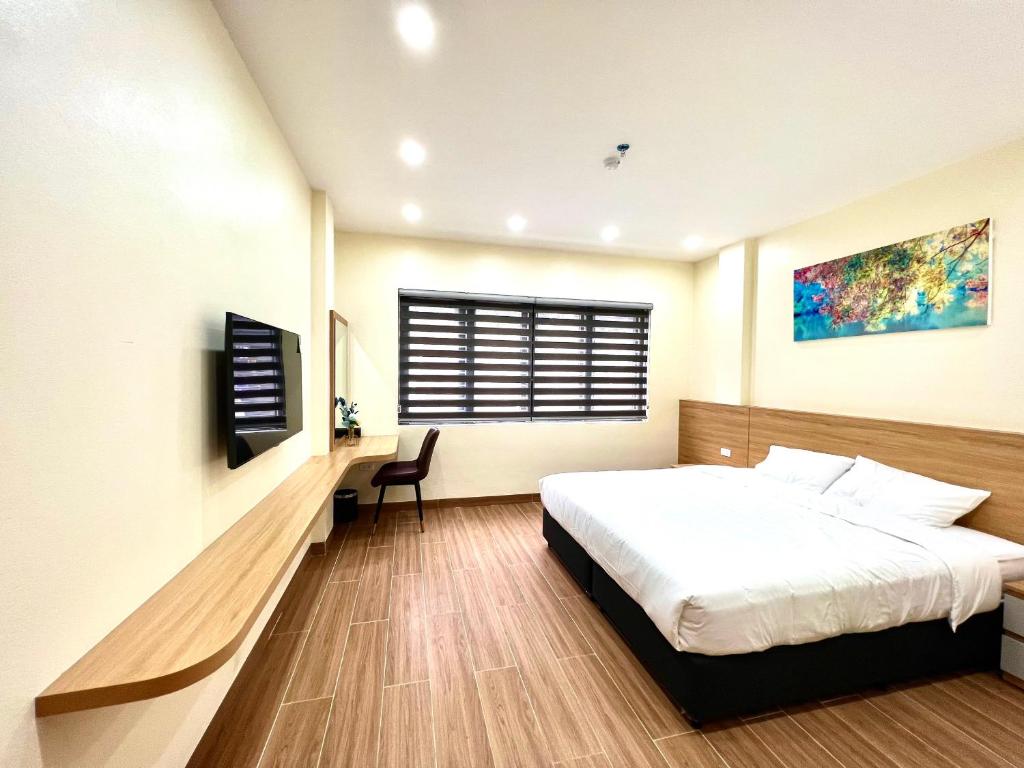 下龙湾Orion Hotel Halong的一间卧室配有一张床、一张书桌和一个窗户。