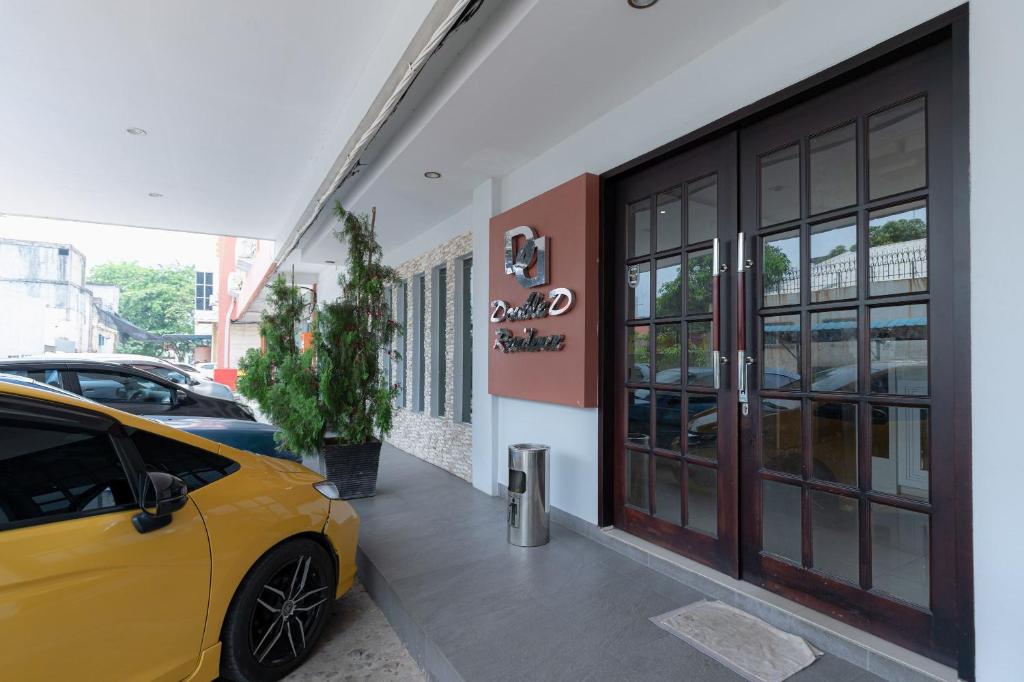 巴淡岛中心邦加拉亚街红门旅馆的停在大楼前的黄色汽车