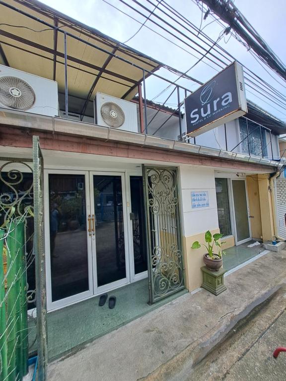 曼谷Sura Hostel and Coworking的一间装有玻璃门的商店,上面有标志