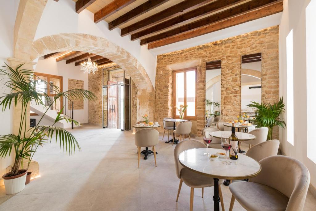 阿尔库迪亚Petit Palau Alcudia - Adults Only的一间带桌椅的餐厅以及砖墙