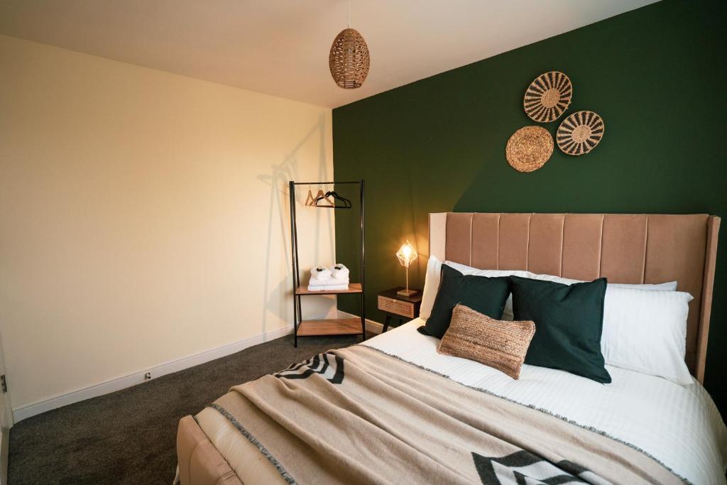 KillingbeckKandaka-Specious Stylish Home - Suitable for Contractors的一间卧室配有一张带绿色墙壁的床