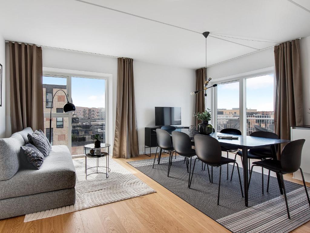 哥本哈根Sanders Arena - Chic Three-Bedroom Apartment Close to Metro Station的一间带桌椅的客厅和一间用餐室