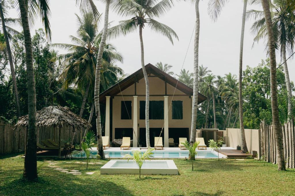 KalametiyaOcean Divine的一个带游泳池和棕榈树的度假村