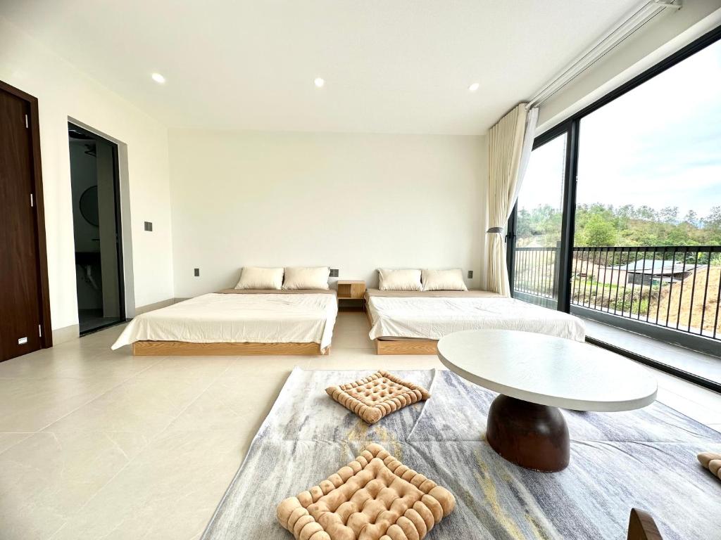 高平Mỡ Villa Cao Bằng的一间卧室设有两张床、一张桌子和大窗户。