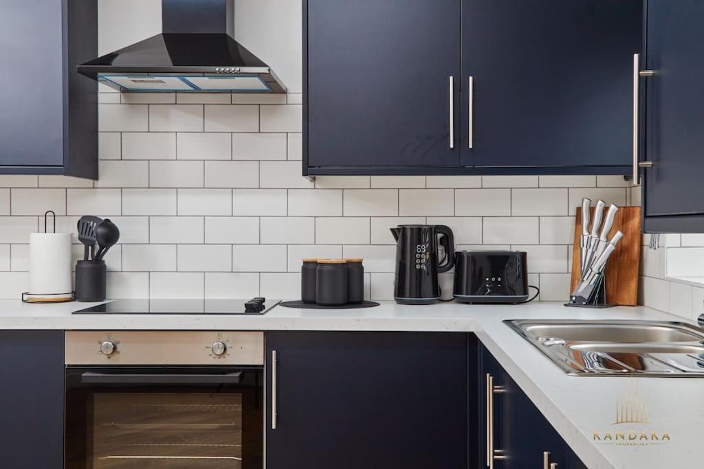 海丁利Stunning 5Bed All En-suite Headingley Home的厨房配有深蓝色橱柜和水槽