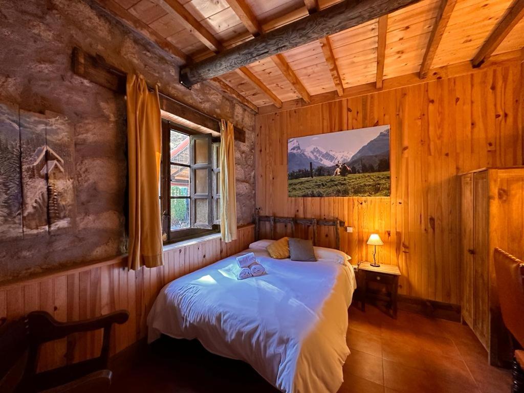 塞尔塞迪利亚La Posada Cercedilla的木制客房内的一间卧室,配有一张床