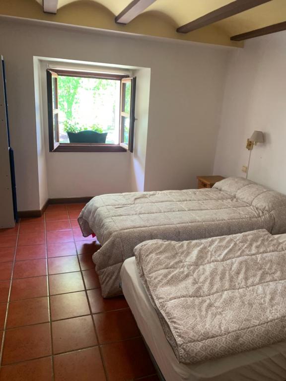 GrañónAlbergue de Nuestra Señora Carrasquedo的客房设有两张床和窗户。