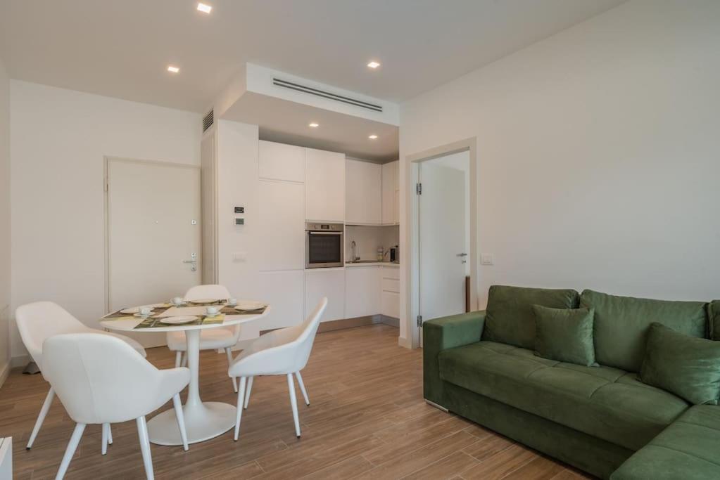 罗马NEW! Exclusive Eur Apartment的客厅配有绿色沙发、桌子和椅子