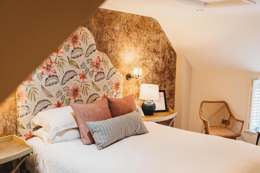 奥克姆芬奇纹章酒店的卧室配有白色床和花卉床头板