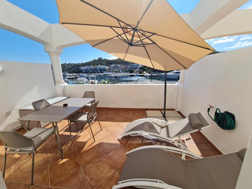 圣特雷莎加卢拉La chicca del porto的阳台配有桌椅和遮阳伞。