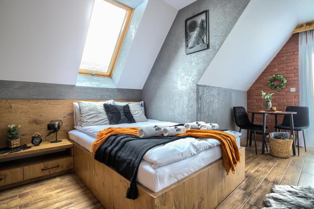 Białka TatrzanskaWolfpack Guest House的一间卧室配有一张带橙色毯子的床