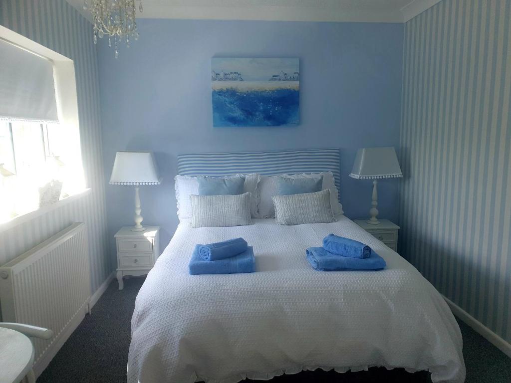罗奇福德HOME from HOME GUEST HOUSE的蓝色卧室,配有带2个蓝色枕头的床