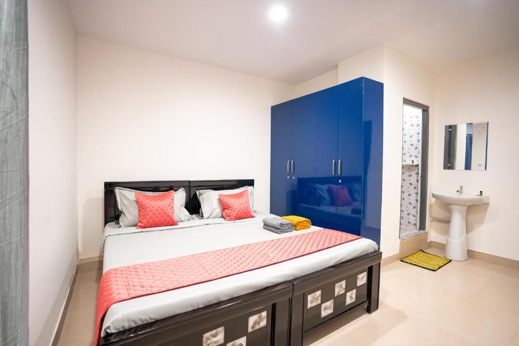 海得拉巴Yellow Bells Signature HITEC City的一间卧室配有一张带蓝色橱柜和水槽的床。
