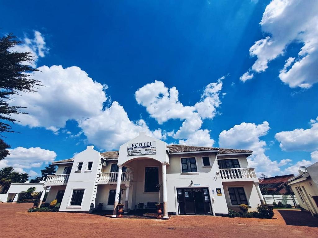 肯普顿帕克OR坦博机场酒店的蓝色天空和云的白色房子