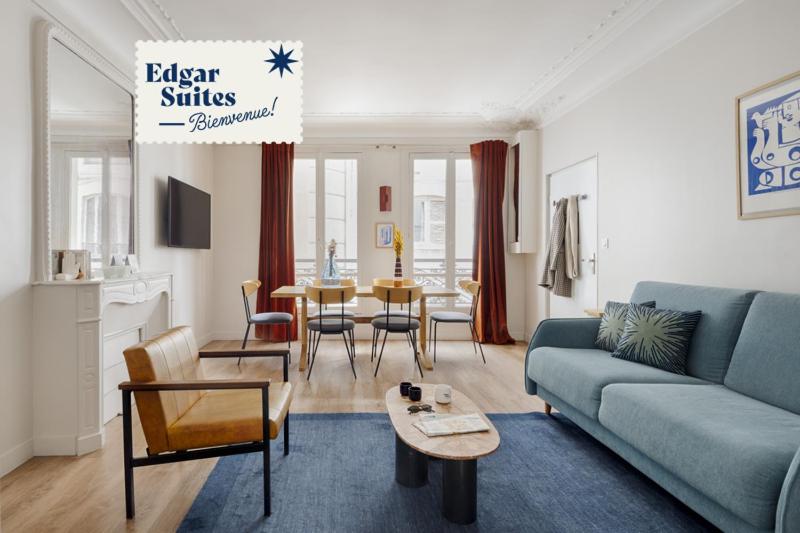 巴黎Edgar Suites Grands Boulevards - Boulanger的客厅配有蓝色的沙发和桌子