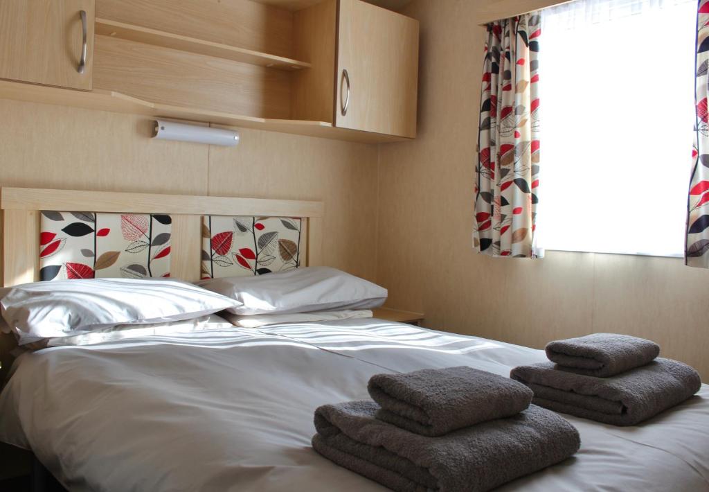 KillichronanCrannich Holiday Caravans的一间卧室配有带毛巾的床