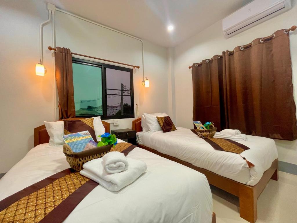 清莱บ้านกาญจน์ เชียงราย Baan Kan Chiang Rai的带2张床、毛巾和窗户的客房