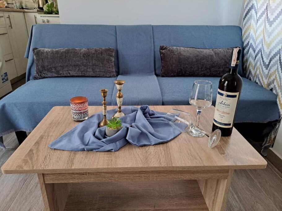 帕拉代西翁Lydia's cozy house的一张桌子,上面放着一瓶葡萄酒和一杯葡萄酒