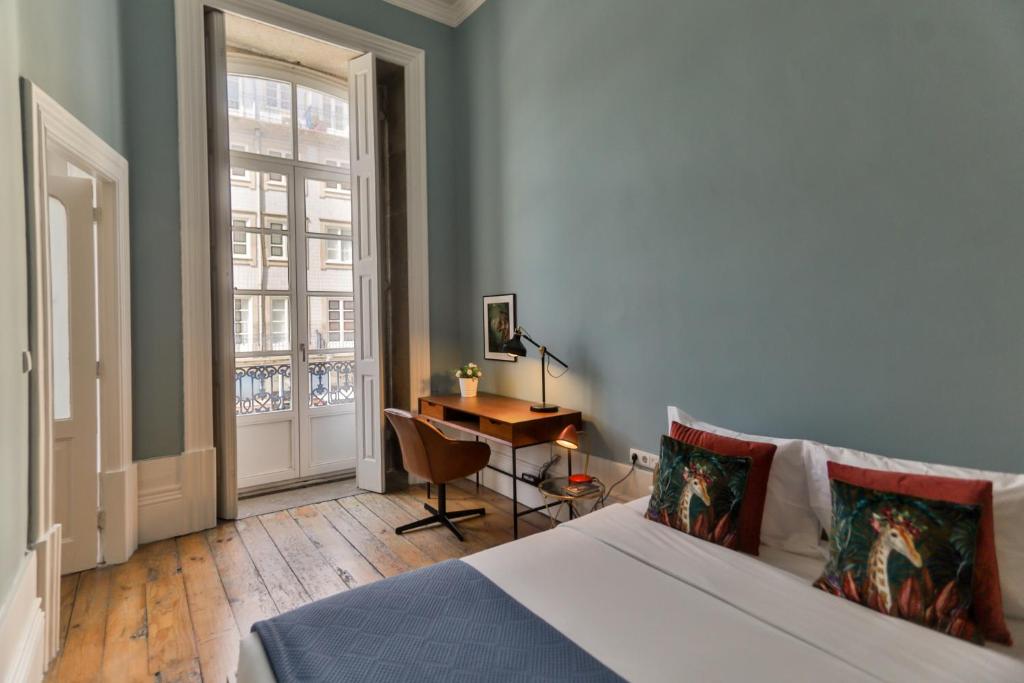 波尔图Adorable Apartments in Great Area的一间卧室配有一张床、一张书桌和一个窗户。