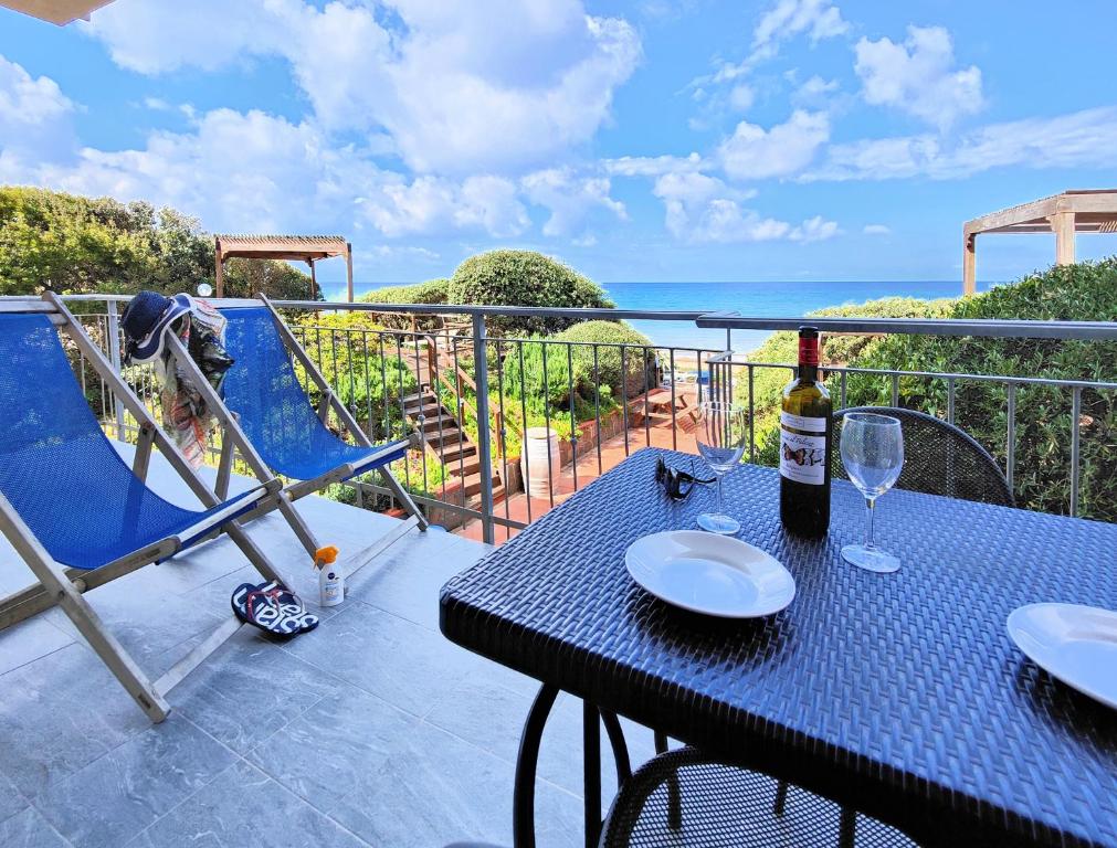 圣温琴佐Le Dune Sea View Apartments - Futura CAV的阳台上的桌子和一瓶葡萄酒