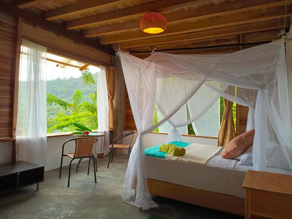 埃尔扎伊诺Frana Lodge的一间卧室设有天蓬床和窗户。
