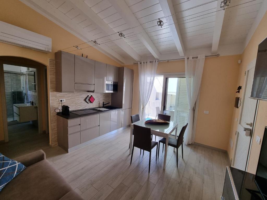罗萨岛Appartamento Spargi的厨房以及带桌椅的起居室。