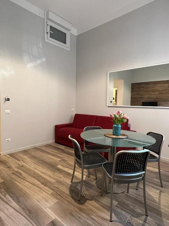米兰Fiori 3 Apartment的客厅配有红色的沙发、桌子和椅子