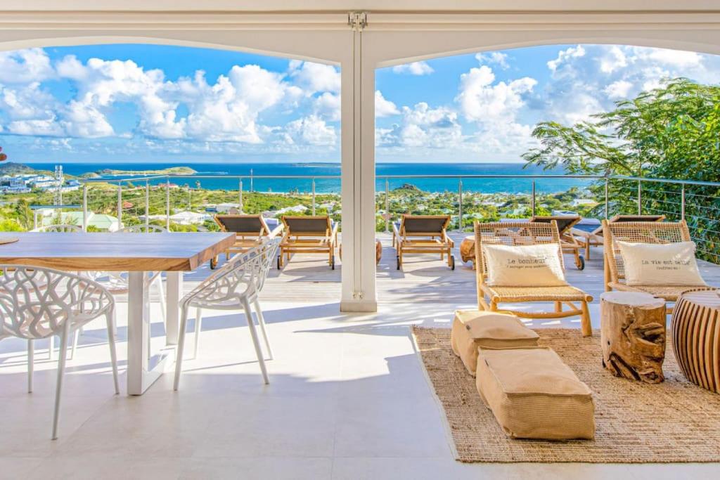 东方湾Casa Del Mar, luxury and magical view of Orient Bay的一个带桌椅的庭院和大海