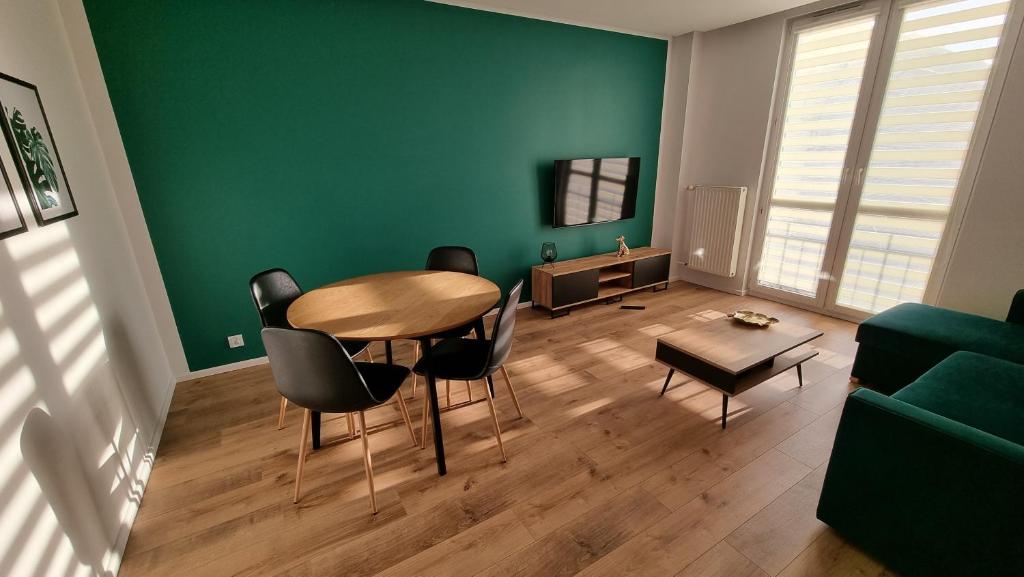 琴斯托霍瓦Apartament w Centrum的客厅配有桌椅和绿色墙壁