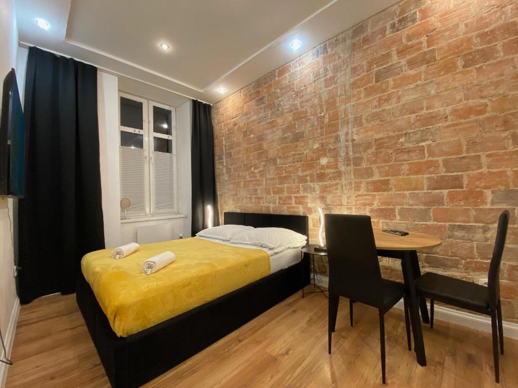 托伦Central Rooms Apartment的一间卧室设有一张床和砖墙