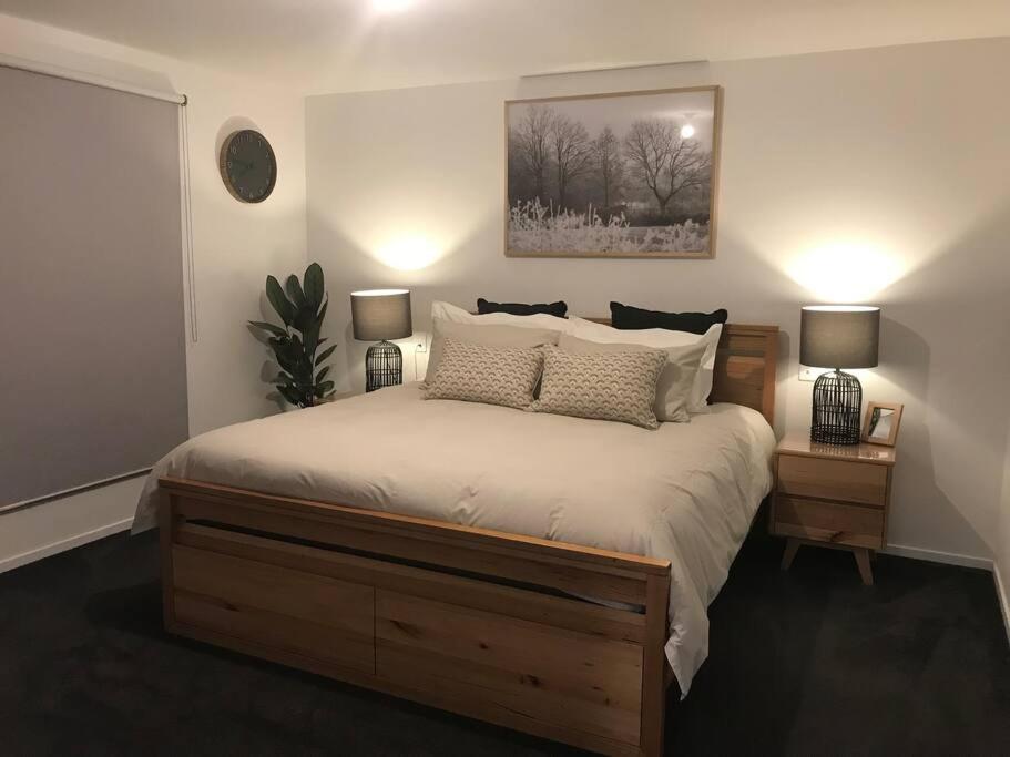 霍巴特Tranquil Retreat 10 Min to Hobart-WIFI Smart TV的一间卧室配有一张带2个床头柜的大床