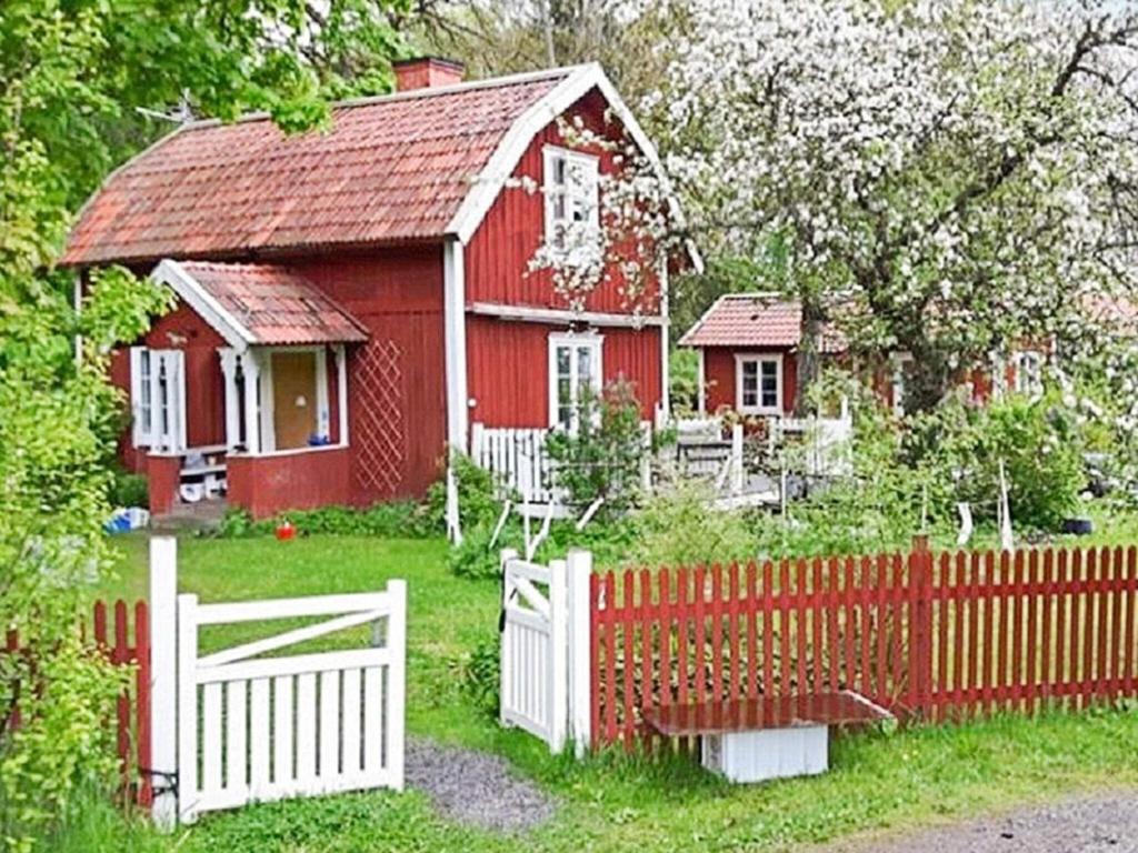 VästerhaningeHoliday home Österhaninge的前面有白色围栏的红色房子